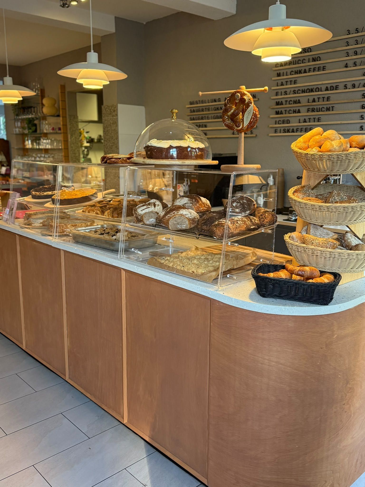 Theke mit Vitrine, Brotkörben, Brezelständer und Getränketafel